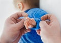 Dad`s hands roll up sleeves on baby`s hand, close-up. Newborn child in the hospital, love and care of the parent`s dad