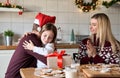Dad in santa hat presenting Christmas gift to kid daughter hugging at home. Royalty Free Stock Photo