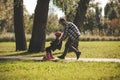 Dad saves his daughter from falling on roller skates in the park. Paternal support and care. Film grain Royalty Free Stock Photo