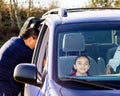 Dad Secures Son In Car Seat As Sisters Wait Patiently