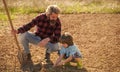 Dad with shovel and boy digging soil. Where food comes from. Teaching son growing plants. Planting plants. Works in