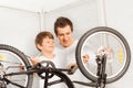 Dad showing his kid son how to repair bicycle