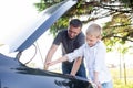 Dad shows his son how the machine works. Open the hood of the car, watch the oil level Royalty Free Stock Photo