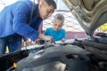 Dad shows his son where to fill in the coolant in the engine compartment. Topping up antifreeze in the car cooling system. Royalty Free Stock Photo