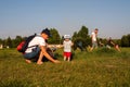 Dad shows his son wild gophers in their natural habitat in a clearing with people resting on a sunny summer day