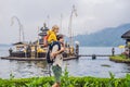 Dad and son in the background of Pura Ulun Danu Bratan, Bali. Hindu temple surrounded by flowers on Bratan lake, Bali Royalty Free Stock Photo