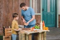 Dad and son cooking meat burgers together Royalty Free Stock Photo