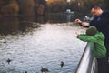 Dad and son feed ducks