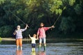 Dad and son fishing at lake. Family fishermen fishing with spinning reel. Grandfather, father and boy fishing together. Royalty Free Stock Photo