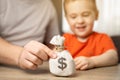 Dad and son are holding a dollar money bag. Family savings and budget. Money saving for child, financial wealth in family Royalty Free Stock Photo