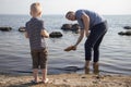 Dad and son launch a ship on the radio. Father shows the boy how to play with the boat on the remote control. The concept of