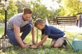 Dad and son planting tree in park Royalty Free Stock Photo