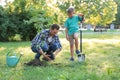 Dad and son planting tree in park on sunny