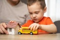 Dad and son play with a house and a school bus. Spending time with children. Royalty Free Stock Photo