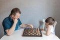 Dad and son are playing a board game of chess. Time and games with children. Logic and strategy game Royalty Free Stock Photo