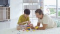 Dad and son playing jigsaw puzzle game toy, building colorful blocks tower together in living room at home in family activity Royalty Free Stock Photo