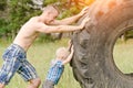 Dad and son push a big tire. Street workout