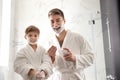 Dad and son with shaving foam on their faces having fun Royalty Free Stock Photo