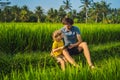 Dad and son sitting on the field holding tablet. Boy sitting on the grass on sunny day. Home schooling or playing a Royalty Free Stock Photo