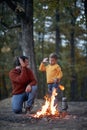 Dad and son starting a fire; Spring or autumn camping with campfire at night ; camping, travel, tourism, hike and people concept. Royalty Free Stock Photo