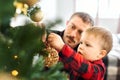 Dad and son together decorating Christmas tree on the eve of holidays. Royalty Free Stock Photo