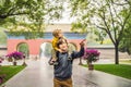 Dad and son are tourists on the background of the large Chinese gates. Travel with children in China concept