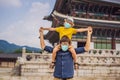 Dad and son tourists in medical mask in Seoul, South Korea. Travel to Korea concept. Traveling with children concept Royalty Free Stock Photo