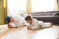 Dad and son in white kimono judo training at home.