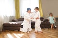 Dad and son in white kimono judo training at home.