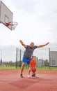 Dad stands in block in front of kid, preventing from throwing ball into basket Royalty Free Stock Photo