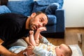 Dad struggling with his baby daughter to change dirty diapers putting faces of effort, concept of fatherhood Royalty Free Stock Photo