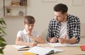 Dad struggling to help his son with school assignment Royalty Free Stock Photo