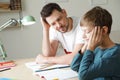 Dad struggling to help his son with school assignment Royalty Free Stock Photo