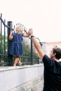 Dad supports the hand of a little girl walking along a stone fence Royalty Free Stock Photo