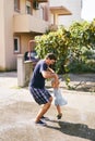 Dad swings a little girl over a puddle, holding her hands Royalty Free Stock Photo