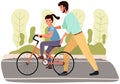 Dad teaches daughter to ride bike for first time. Father is helping girl kid to balance on bicycle Royalty Free Stock Photo