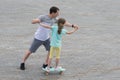 Dad teaches daughter to skateboard in a city park Royalty Free Stock Photo