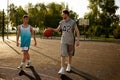 Dad and teenager son walking on urban basketball field