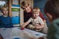 Dad with three sons playing in kids room, air hockey. Concept of Father's Day, and fatherly love. Real family, real Royalty Free Stock Photo