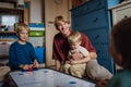 Dad with three sons playing in kids room, air hockey. Concept of Father& x27;s Day, and fatherly love. Real family, real Royalty Free Stock Photo