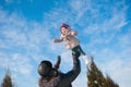 Dad throws up baby daughter in winter against the blue sky, lifestyle, winter holidays Royalty Free Stock Photo