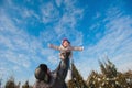 Dad throws up baby daughter in winter against the blue sky, lifestyle, winter holidays Royalty Free Stock Photo