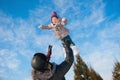 Dad throws up baby daughter in winter against the blue sky, lifestyle, winter holidays Royalty Free Stock Photo