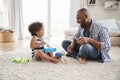 Dad and toddler daughter playing instruments in sitting room Royalty Free Stock Photo