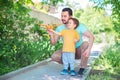 Dad and toddler son together launch toy airplane, both man and boy are looking at plane. Father and son spending good time Royalty Free Stock Photo
