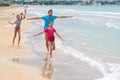 Dad with two children running merrily along the seashore