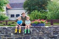 Dad and two little kid boys sitting together on stone bridge Royalty Free Stock Photo