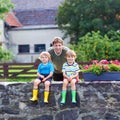 Dad and two little kid boys sitting together on stone bridge Royalty Free Stock Photo