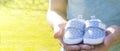 Dad waiting birth of him first son. Man holding small blue baby shoes in hands. Happy parents concept. Pregnant concept.