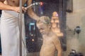 Dad washes his son`s hair in the shower in the evening before going to sleep on the background of a window with a